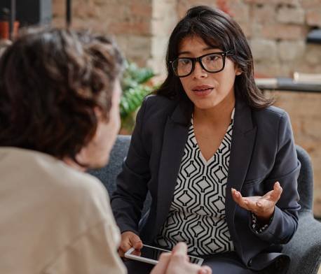 Una mujer terapeuta en su consulta hablando con su paciente.